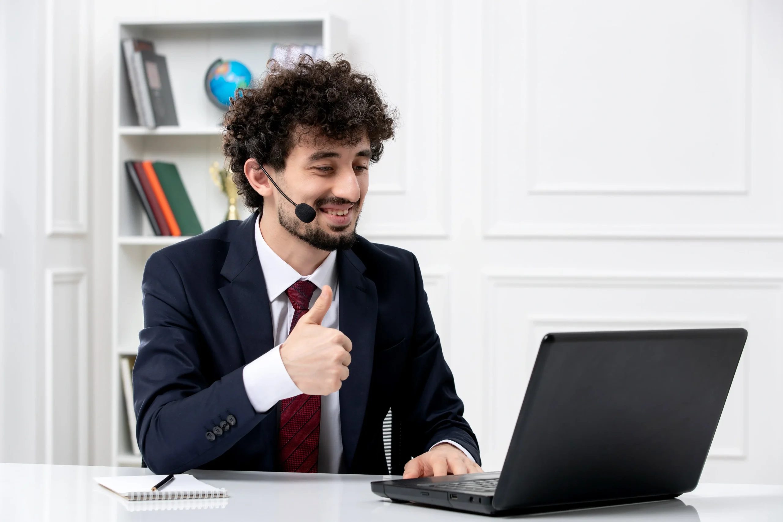 Customer service handsome young guy office suit with laptop headset smiling happily min 1 scaled